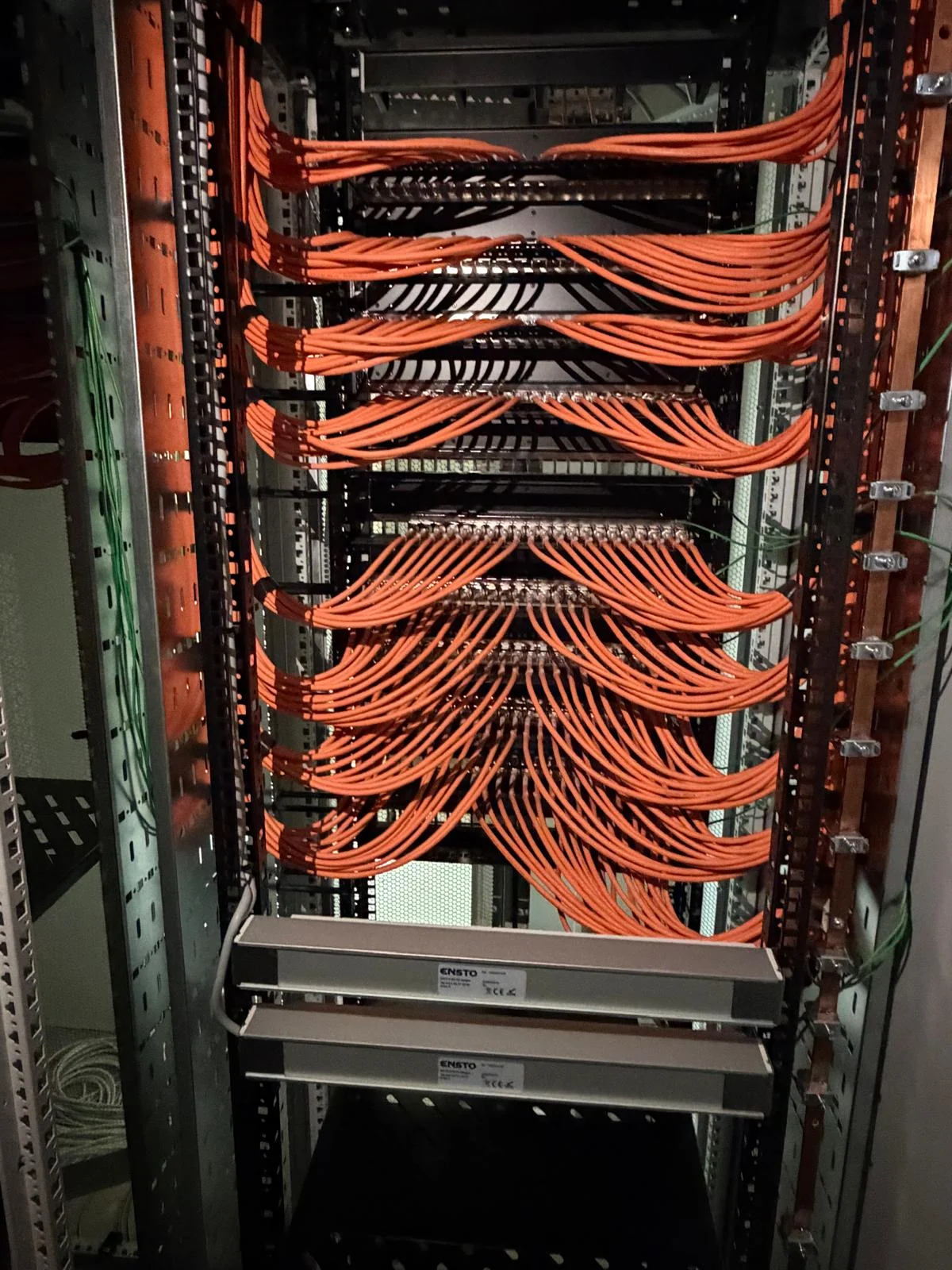 Afgewerkte oranje patchbekabeling in datakast